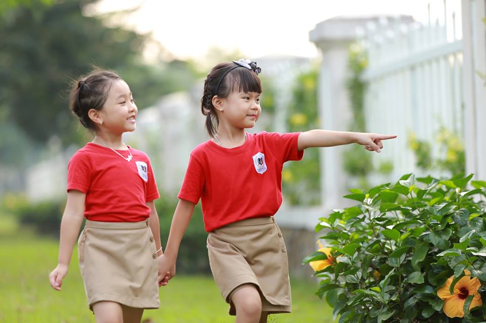 Trẻ mặc đồng phục mầm non đỏ tươi vui đùa ngoài trời