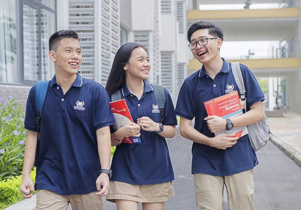 Học sinh Vinschool mặc đồng phục polo xanh navy cười nói vui vẻ
